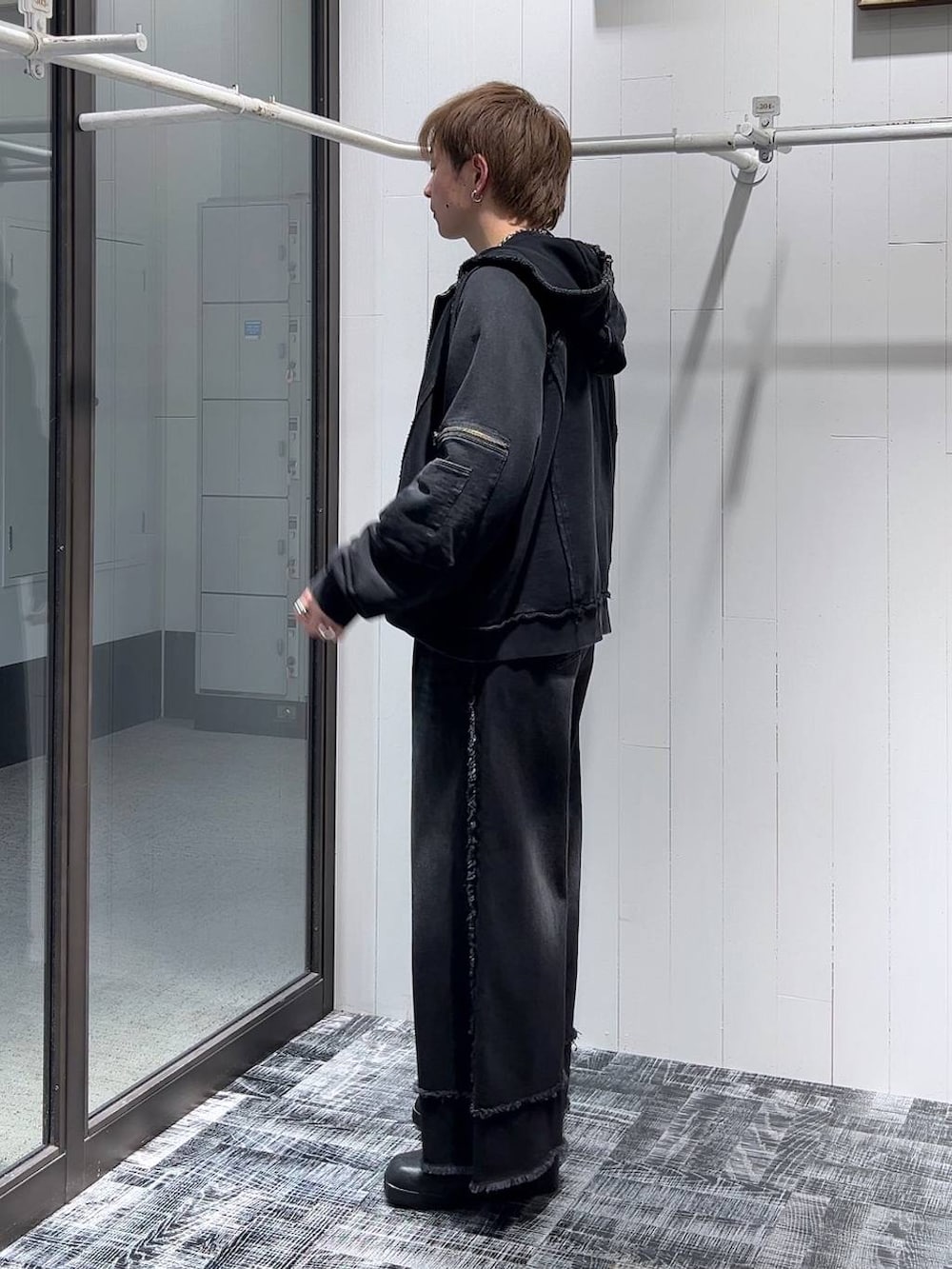 ブラック系のパーカー、ブラック系のブーツ、ブラック系のデニムパンツを着用したメンズの冬コーディネートの4枚目の写真