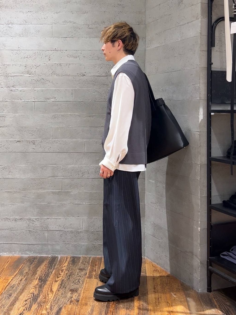 ブラック系のトートバッグ、ブラック系のドレスシューズ、グレー系のベストを着用したメンズの夏コーディネートの4枚目の写真