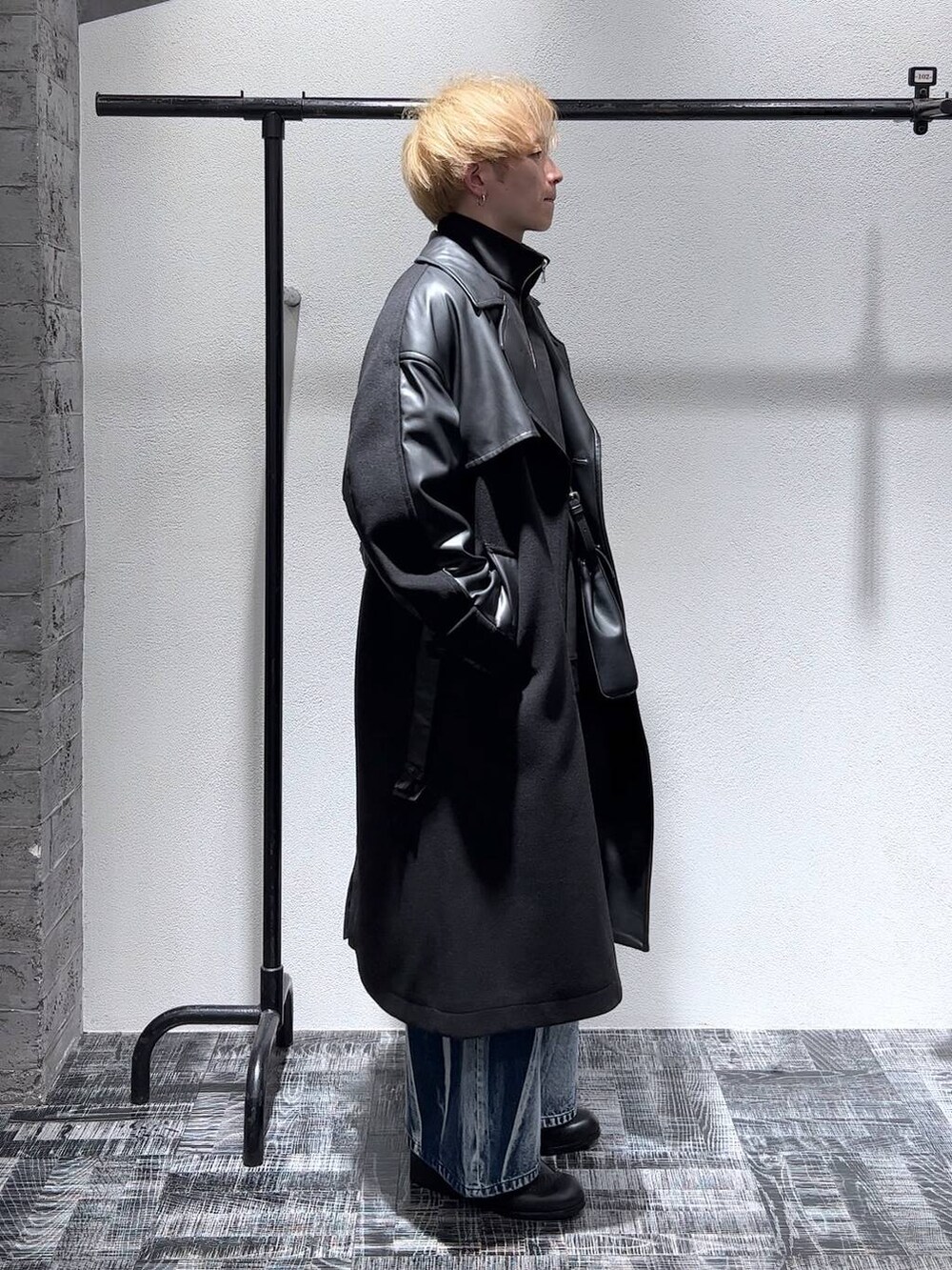 ブラック系のトレンチコート、ブラック系のショルダーバッグ、ブラック系のスウェットを着用したメンズの秋コーディネートの3枚目の写真