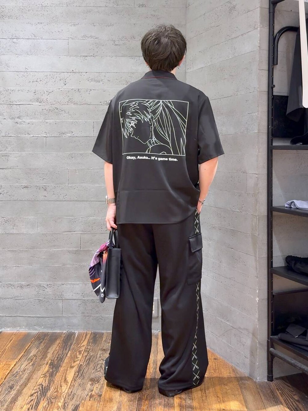 ブラック系のカーゴパンツ、レッド系のシャツ/ブラウス、ブラック系のサンダルを着用したメンズの夏コーディネートの3枚目の写真