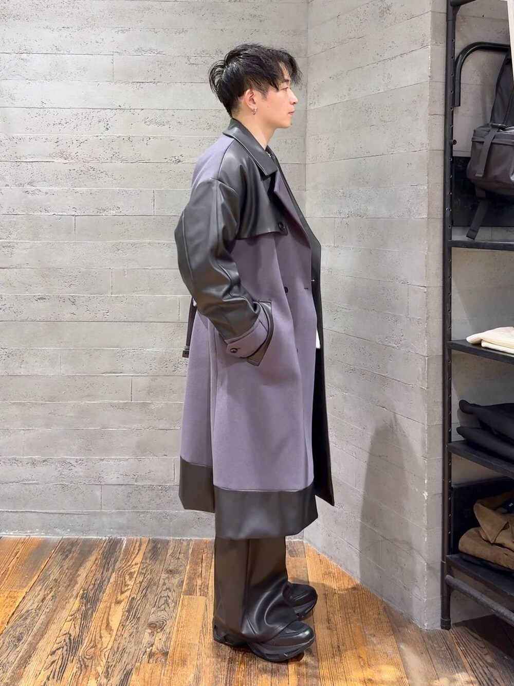 パープル系のトレンチコート、グレー系のニット/セーター、ブラック系のスラックスを着用したメンズの秋コーディネートの2枚目の写真