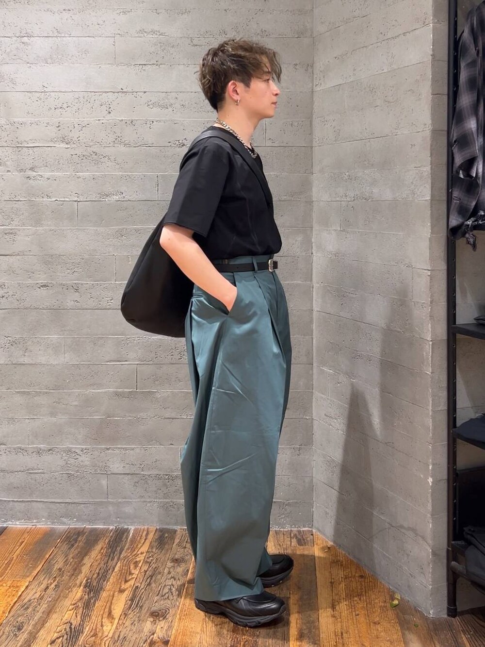 ブラック系のローファー、ブラック系のショルダーバッグ、グリーン系のチノパンツを着用したメンズの夏コーディネートの2枚目の写真