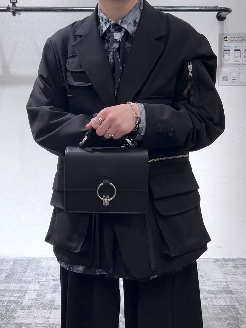 ブラック系のテーラードジャケット、ブラック系のショルダーバッグ、ブラック系のスラックスを着用したメンズの冬コーディネートの5枚目の写真