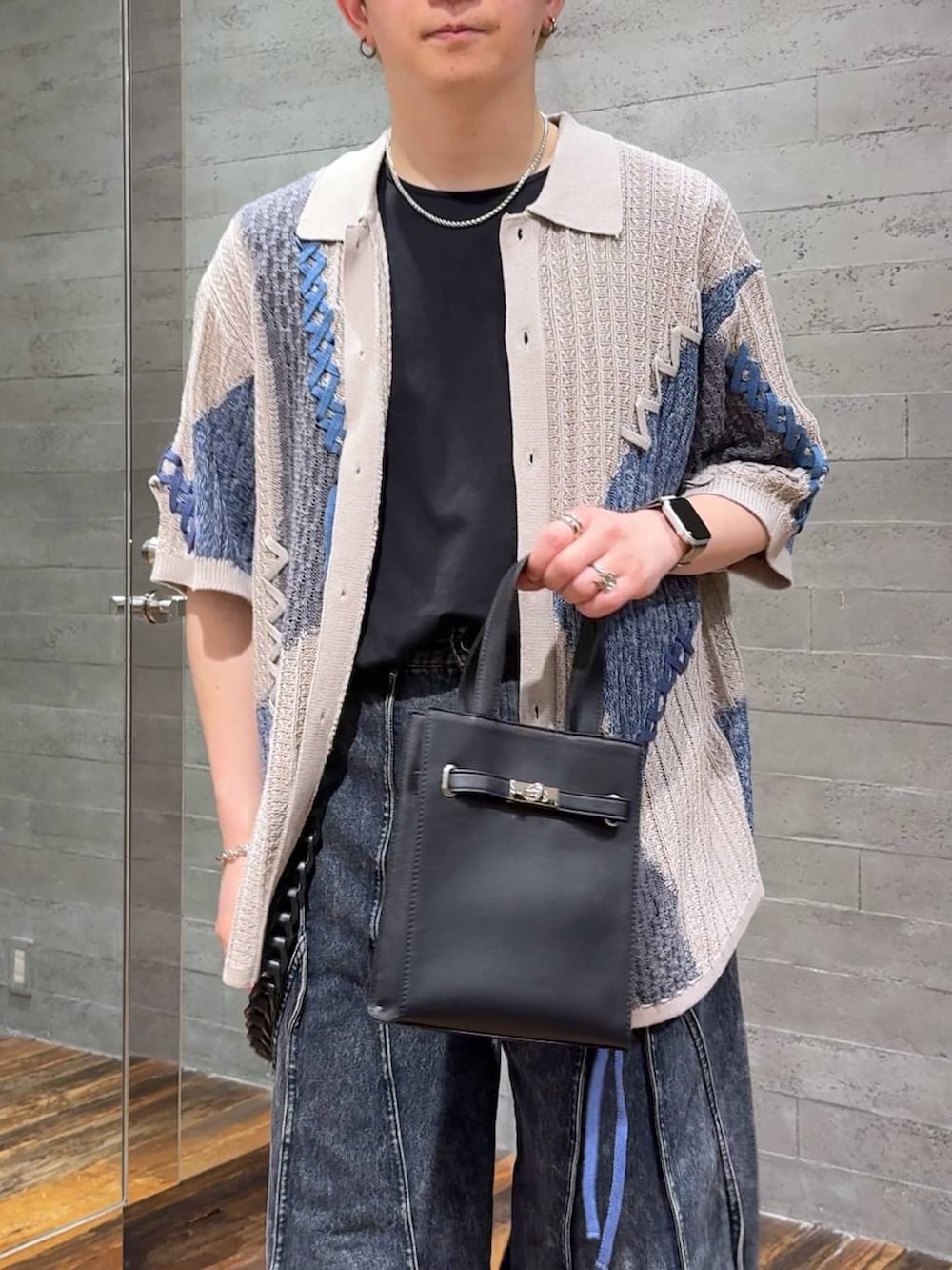 ブルー系のデニムパンツ、ブラック系のTシャツ/カットソー、ブラック系のサンダルを着用したメンズの夏コーディネートの5枚目の写真