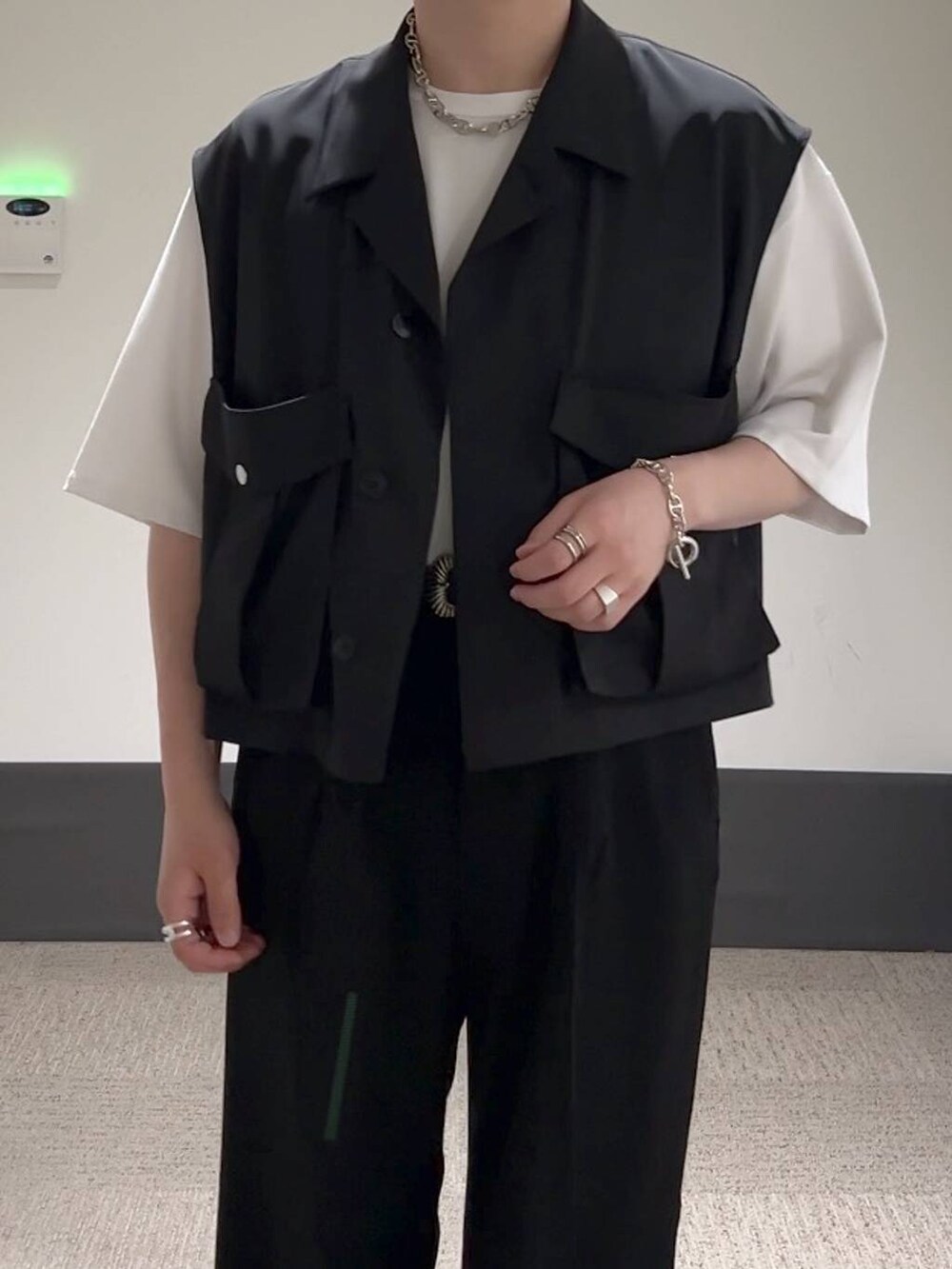 ブラック系のスラックス、ホワイト系のTシャツ/カットソー、ブラック系のサンダルを着用したメンズの夏コーディネートの4枚目の写真