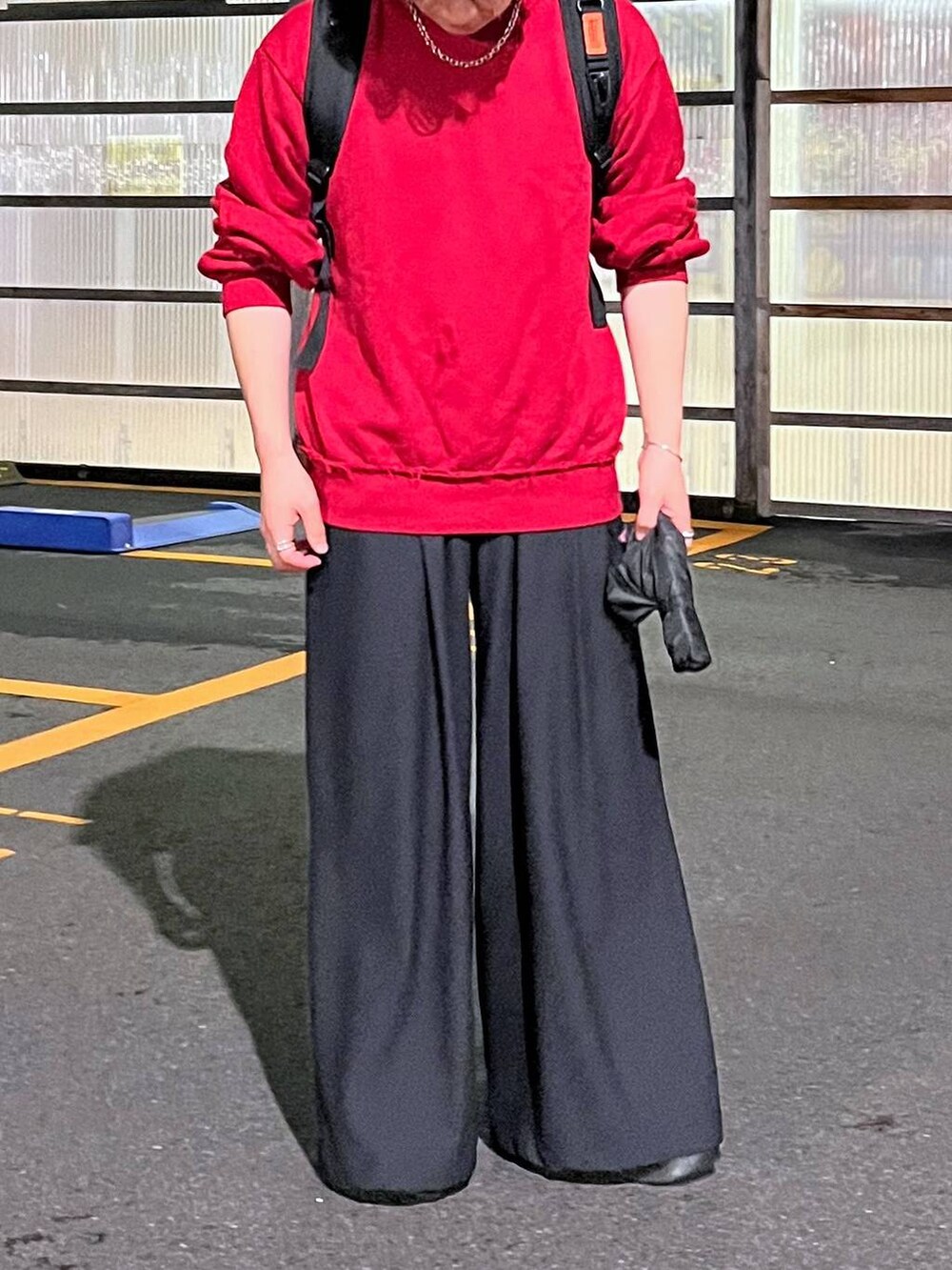 ブラック系のその他パンツ、レッド系のスウェット、シルバー系のピアス（片耳用）を着用したメンズの秋コーディネートの4枚目の写真