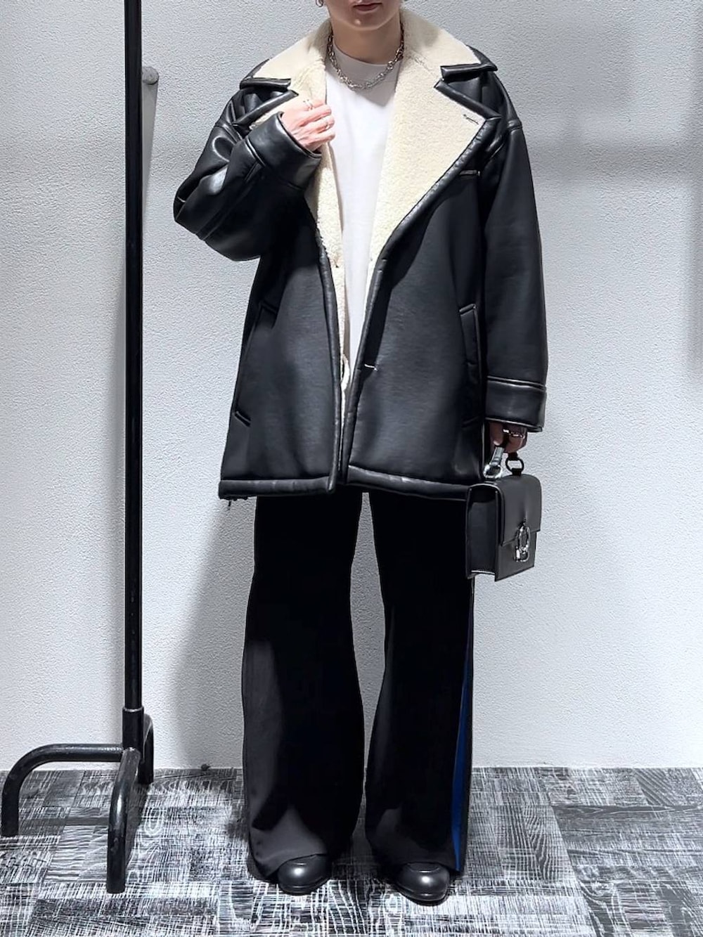 グレー系のスウェット、ブラック系のショルダーバッグ、ブラック系のブーツを着用したメンズの冬コーディネートの2枚目の写真