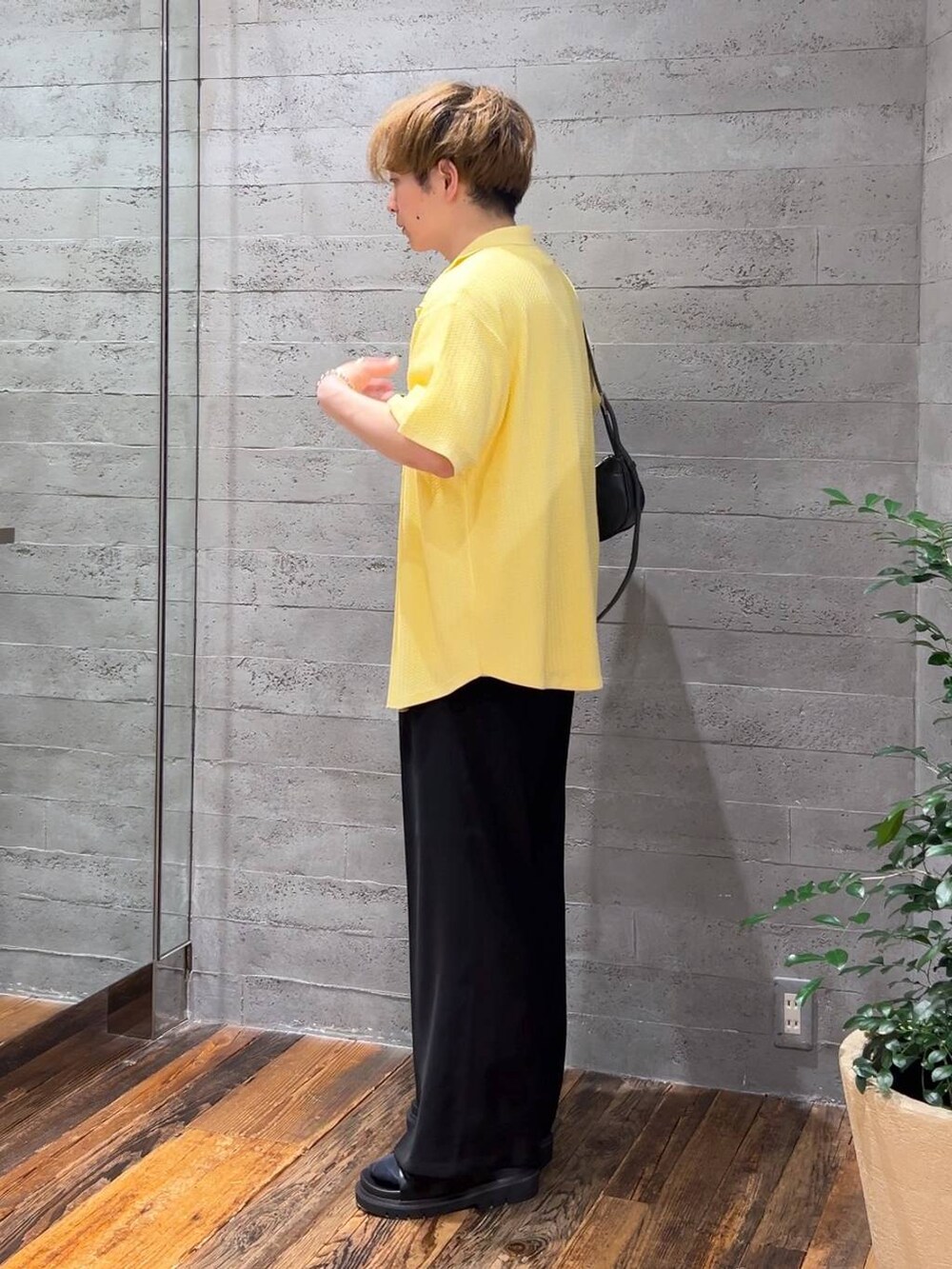 ブラック系のスラックス、ブラック系のショルダーバッグ、ブラック系のサンダルを着用したメンズの夏コーディネートの4枚目の写真