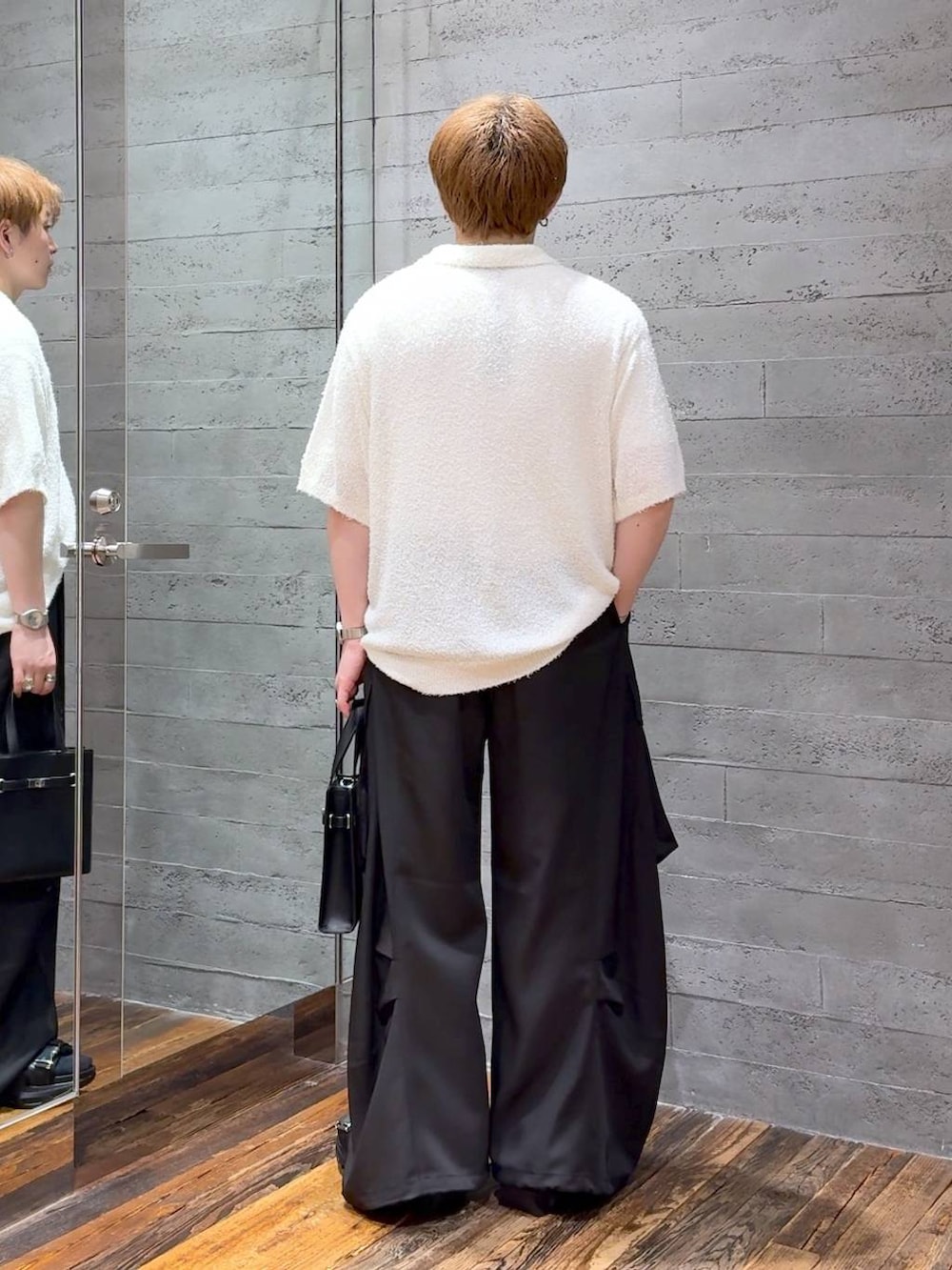 ブラック系のサンダル、ホワイト系のTシャツ/カットソー、ブラック系のカーゴパンツを着用したメンズの夏コーディネートの3枚目の写真
