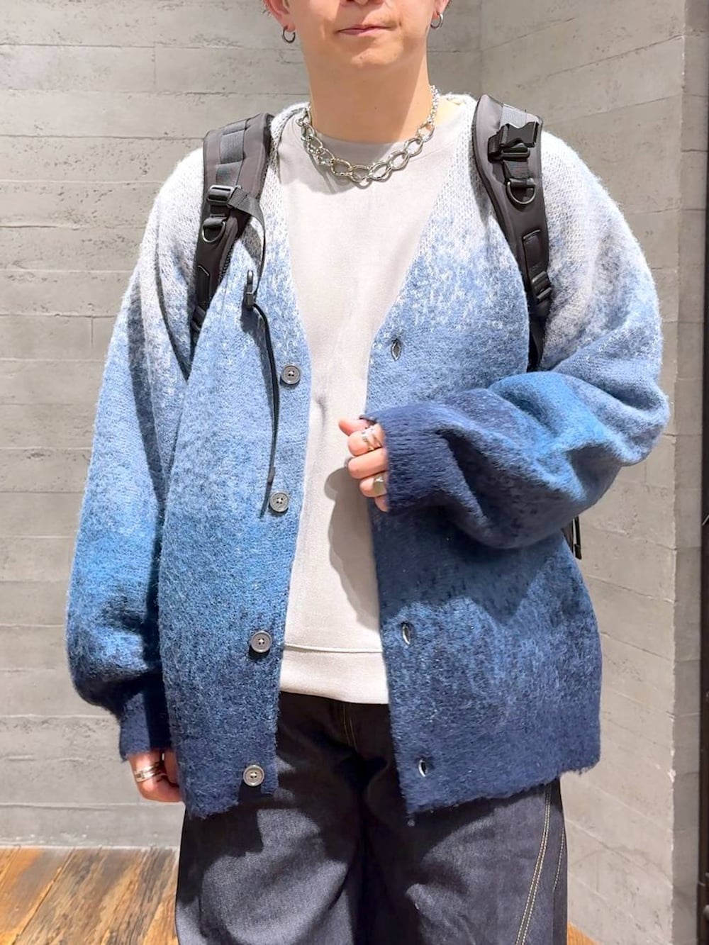 ブルー系のデニムパンツ、ブルー系のカーディガン/ボレロ、ブラック系のバックパック/リュックを着用したメンズの秋コーディネートの5枚目の写真