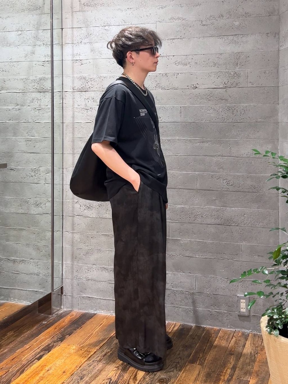 ブラック系のサンダル、グレー系のスラックス、ブラック系のTシャツ/カットソーを着用したメンズの夏コーディネートの2枚目の写真