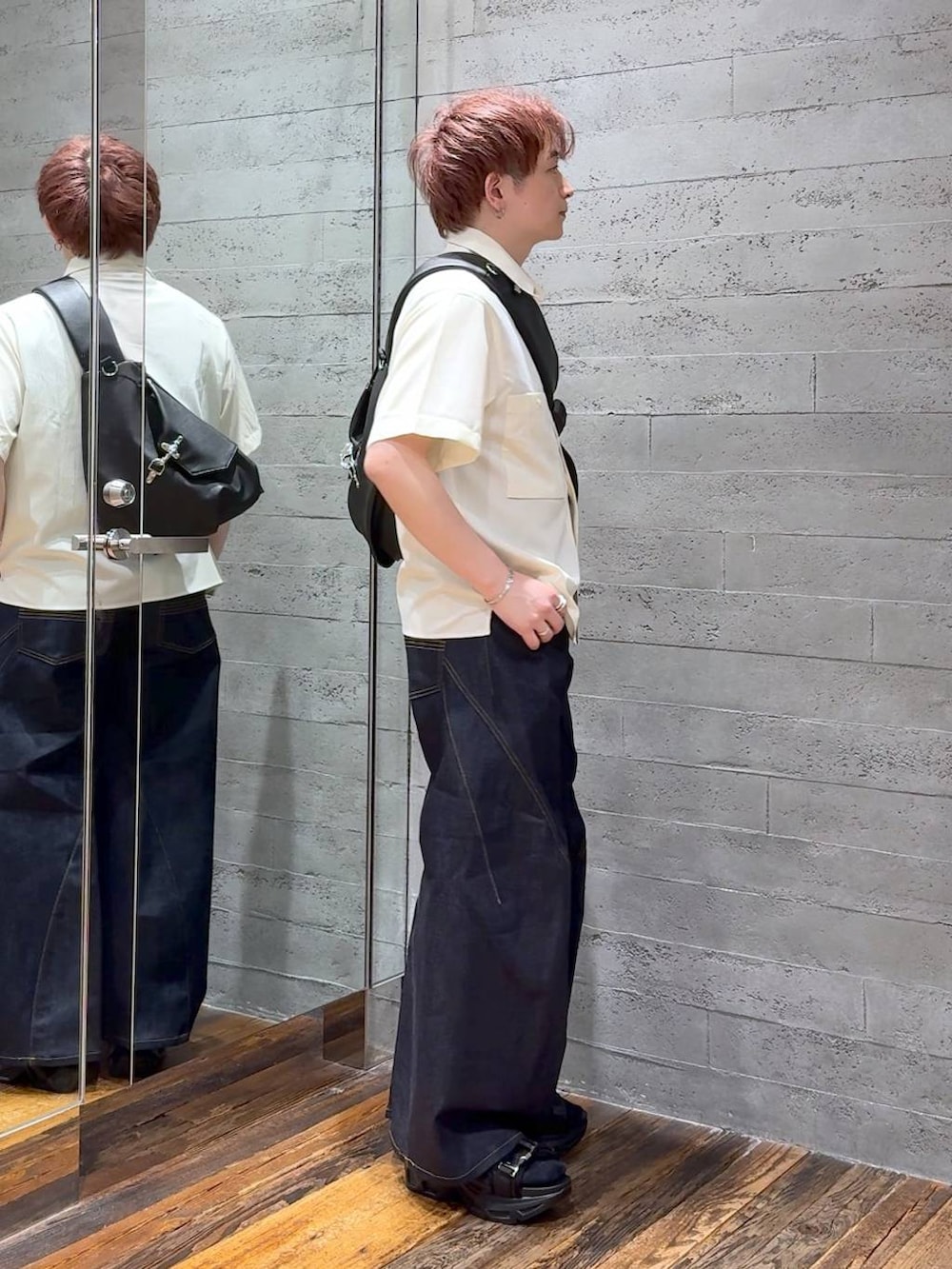 ブラック系のサンダル、ブルー系のデニムパンツ、ブラック系のショルダーバッグを着用したメンズの夏コーディネートの2枚目の写真