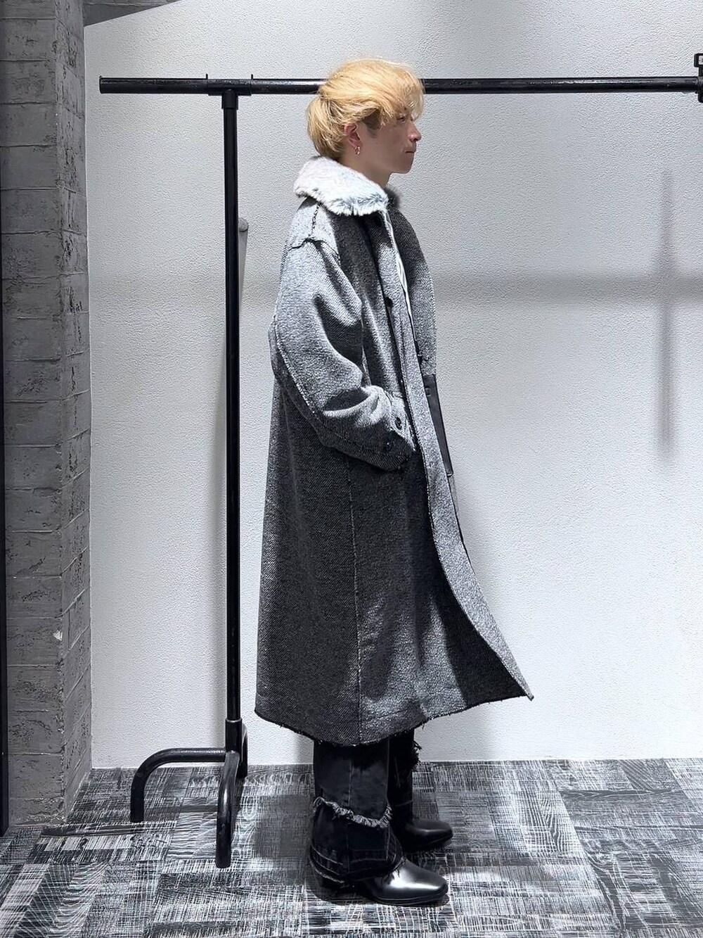 ブラック系のドレスシューズ、ブラック系のショルダーバッグ、ブラック系のデニムパンツを着用したメンズの冬コーディネートの3枚目の写真