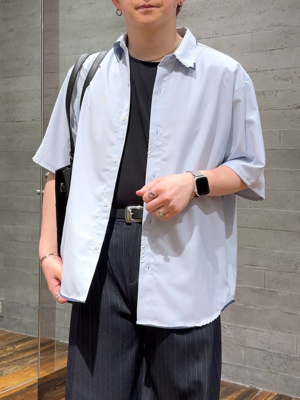 ブラック系のサンダル、ブラック系のTシャツ/カットソー、ブルー系のスラックスを着用したメンズの夏コーディネートの5枚目の写真