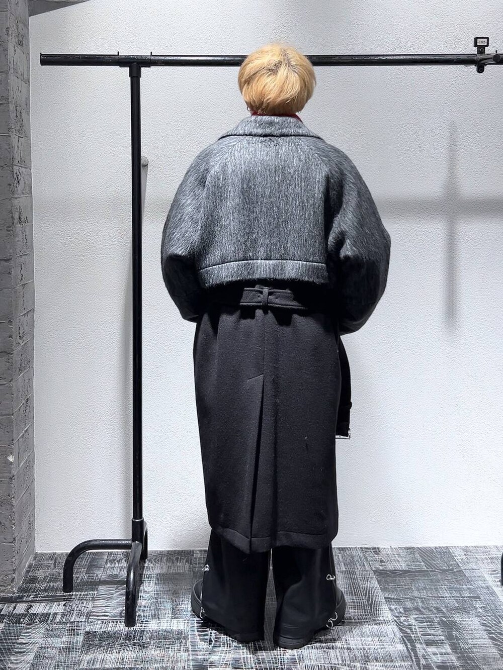 ブラック系のブーツ、ブラック系のダッフルコート、レッド系のニット/セーターを着用したメンズの秋コーディネートの4枚目の写真