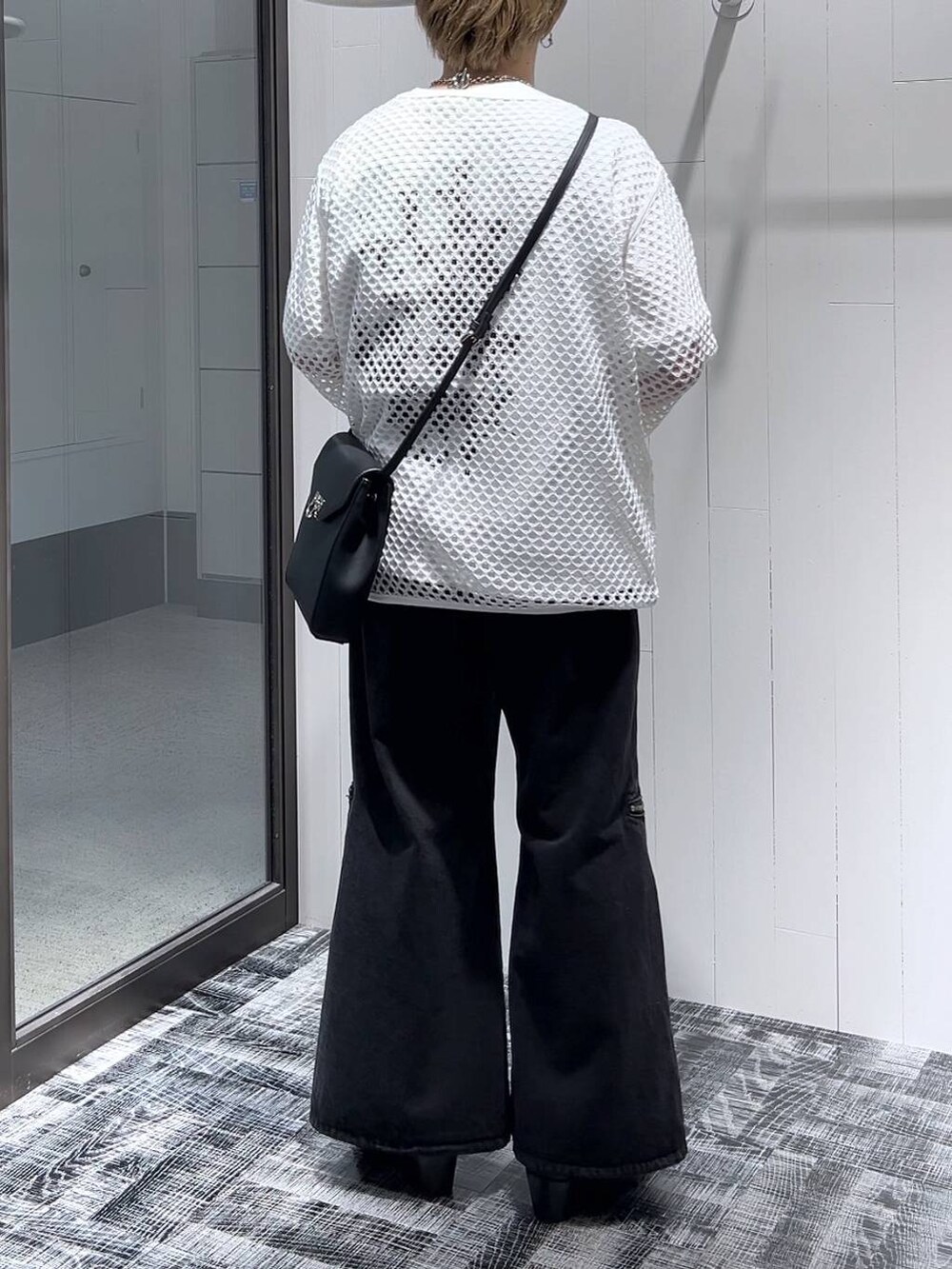 ブラック系のショルダーバッグ、ブラック系のデニムパンツ、ブラック系のドレスシューズを着用したメンズの春コーディネートの3枚目の写真