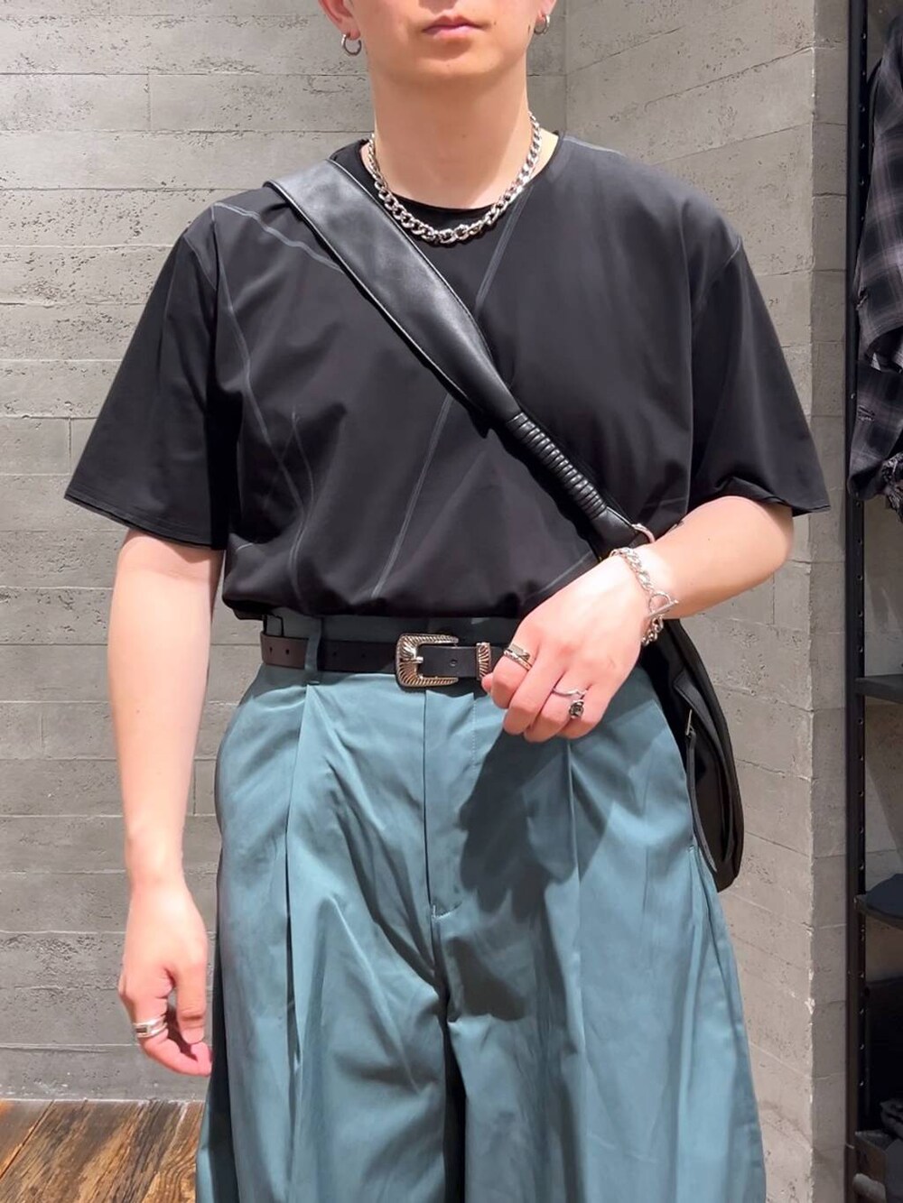 ブラック系のローファー、ブラック系のショルダーバッグ、グリーン系のチノパンツを着用したメンズの夏コーディネートの5枚目の写真