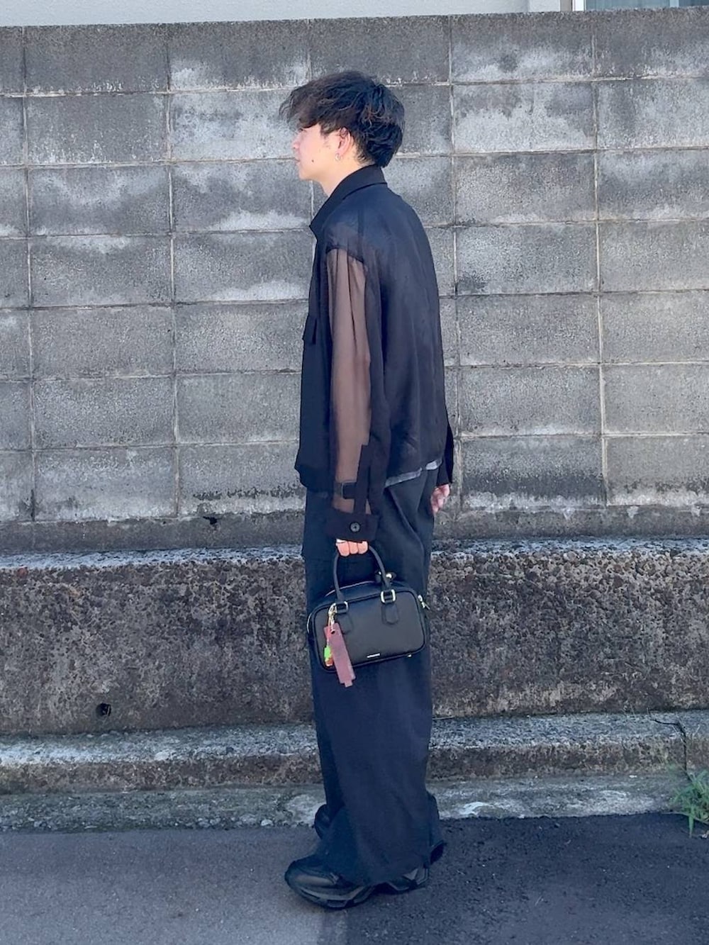 ブラック系のボストンバッグ、ブラック系のスニーカーを着用したメンズの秋コーディネートの4枚目の写真