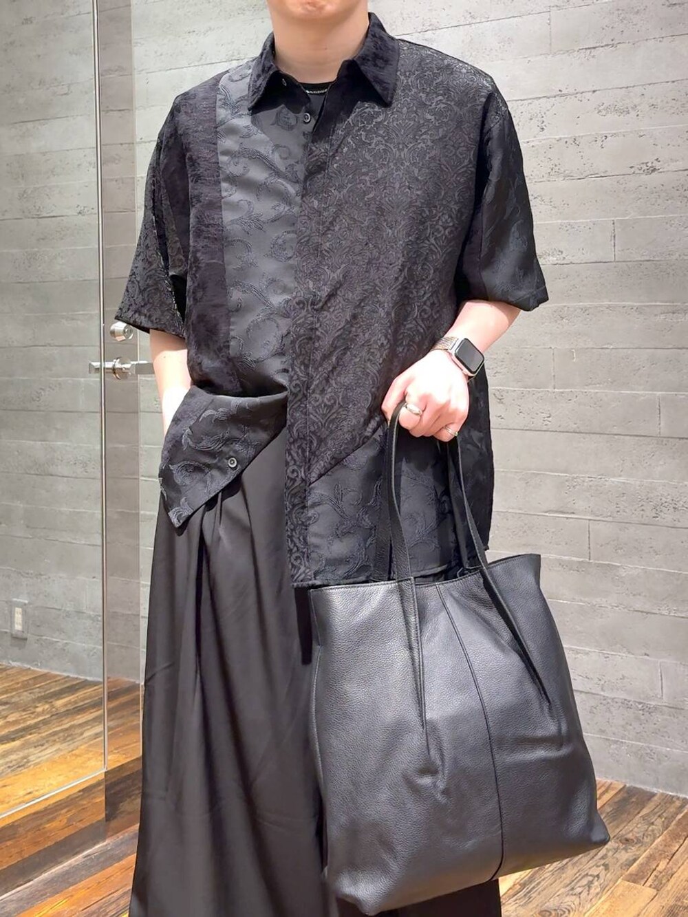 ブラック系のサンダル、ブラック系のTシャツ/カットソー、ブラック系のトートバッグを着用したメンズの春コーディネートの5枚目の写真