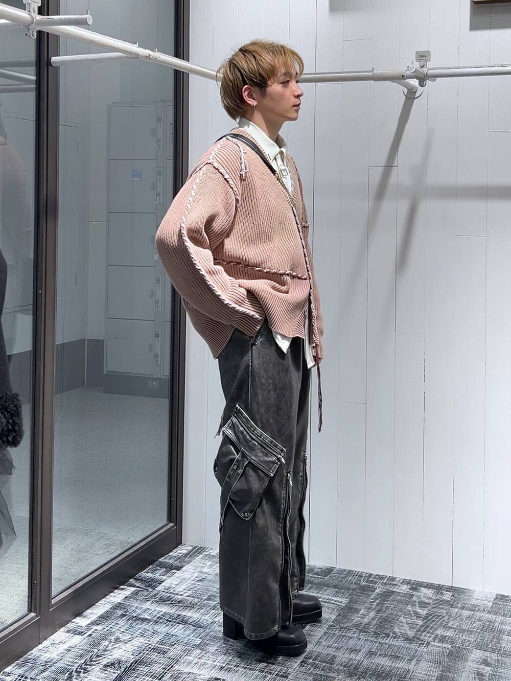 グレー系のカーゴパンツ、ブラック系のショルダーバッグ、ピンク系のカーディガン/ボレロを着用したメンズの冬コーディネートの2枚目の写真