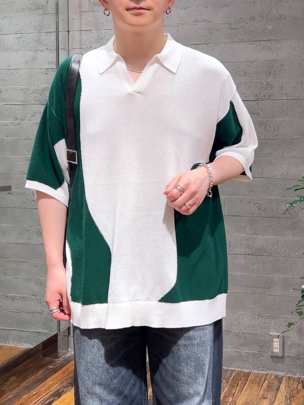 グレー系のショルダーバッグ、ブラック系のサンダル、ブルー系のデニムパンツを着用したメンズの夏コーディネートの5枚目の写真