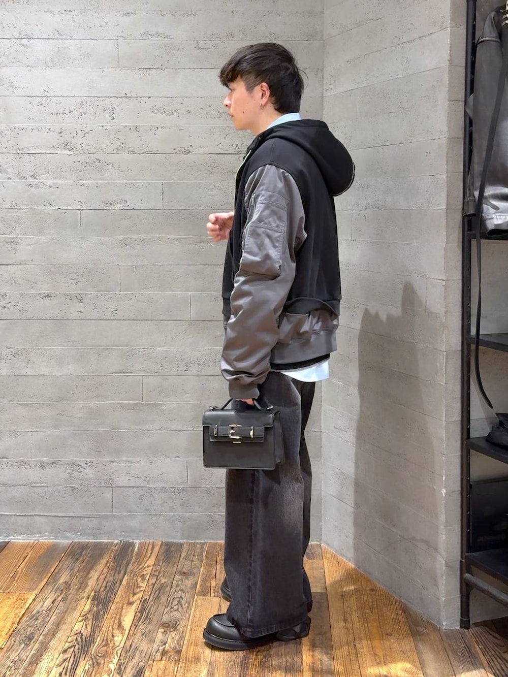 ブラック系のデニムパンツ、ブラック系のポロシャツ、ブラック系のローファーを着用したメンズの冬コーディネートの4枚目の写真
