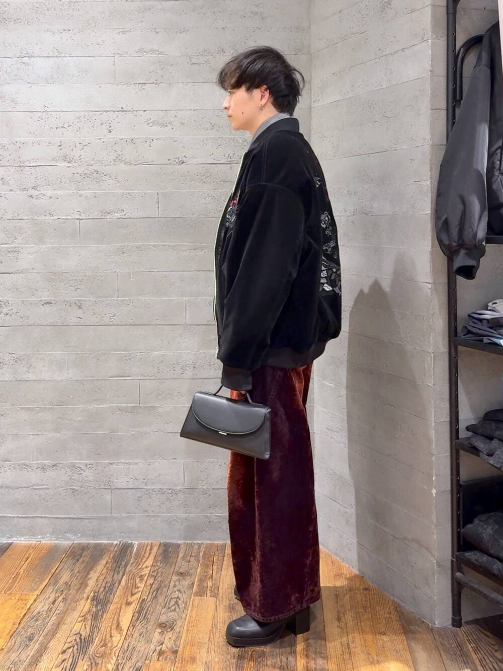 ブラック系のブーツ、レッド系のデニムパンツ、ブラック系のショルダーバッグを着用したメンズの冬コーディネートの4枚目の写真