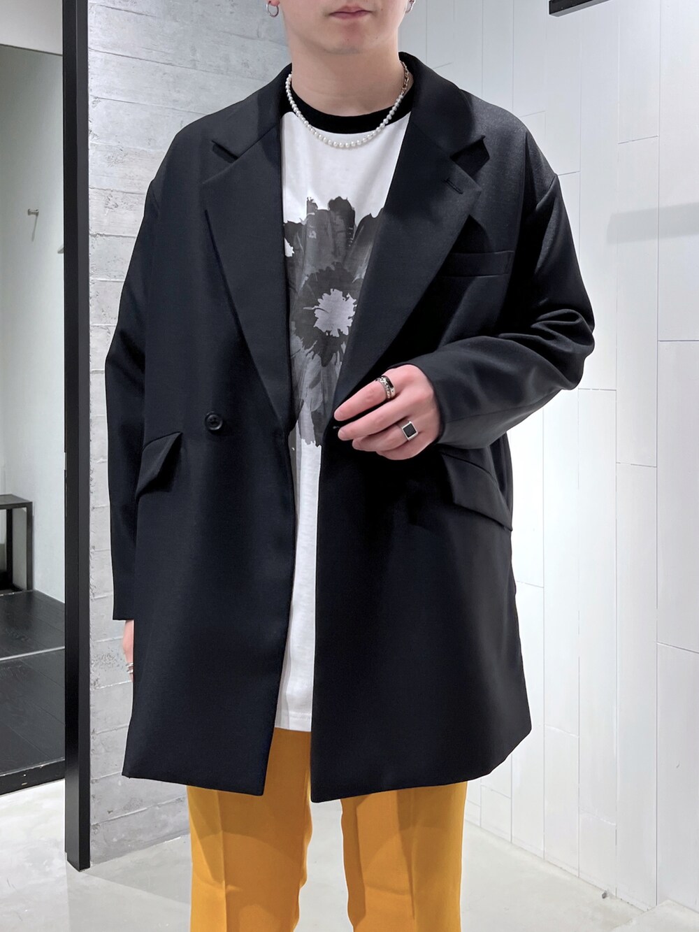 ブラック系のTシャツ/カットソー、ブラック系のテーラードジャケット、イエロー系のスラックスを着用したメンズの春コーディネートの5枚目の写真