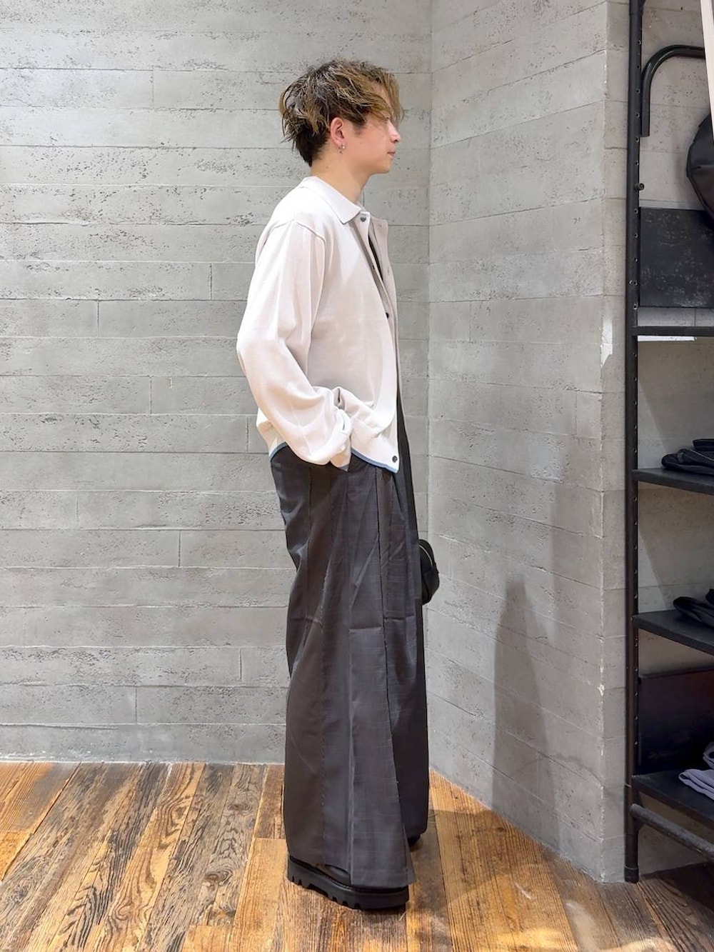 ブラック系のドレスシューズ、ブラック系のボストンバッグ、グレー系のニット/セーターを着用したメンズの夏コーディネートの2枚目の写真