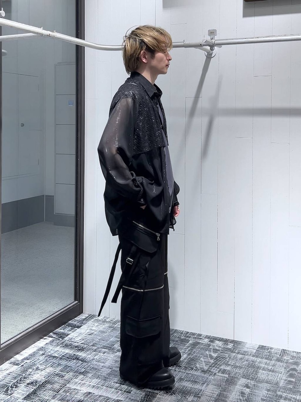 ブラック系のカーゴパンツ、ブラック系のショルダーバッグ、ブラック系のドレスシューズを着用したメンズの春コーディネートの3枚目の写真