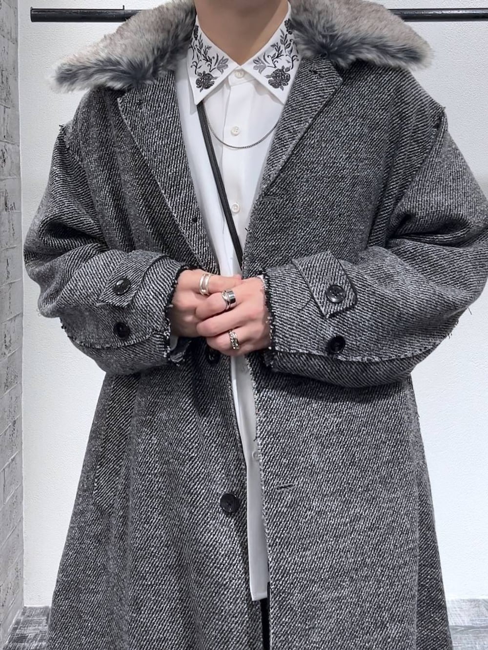 ブラック系のドレスシューズ、ブラック系のショルダーバッグ、ブラック系のデニムパンツを着用したメンズの冬コーディネートの5枚目の写真