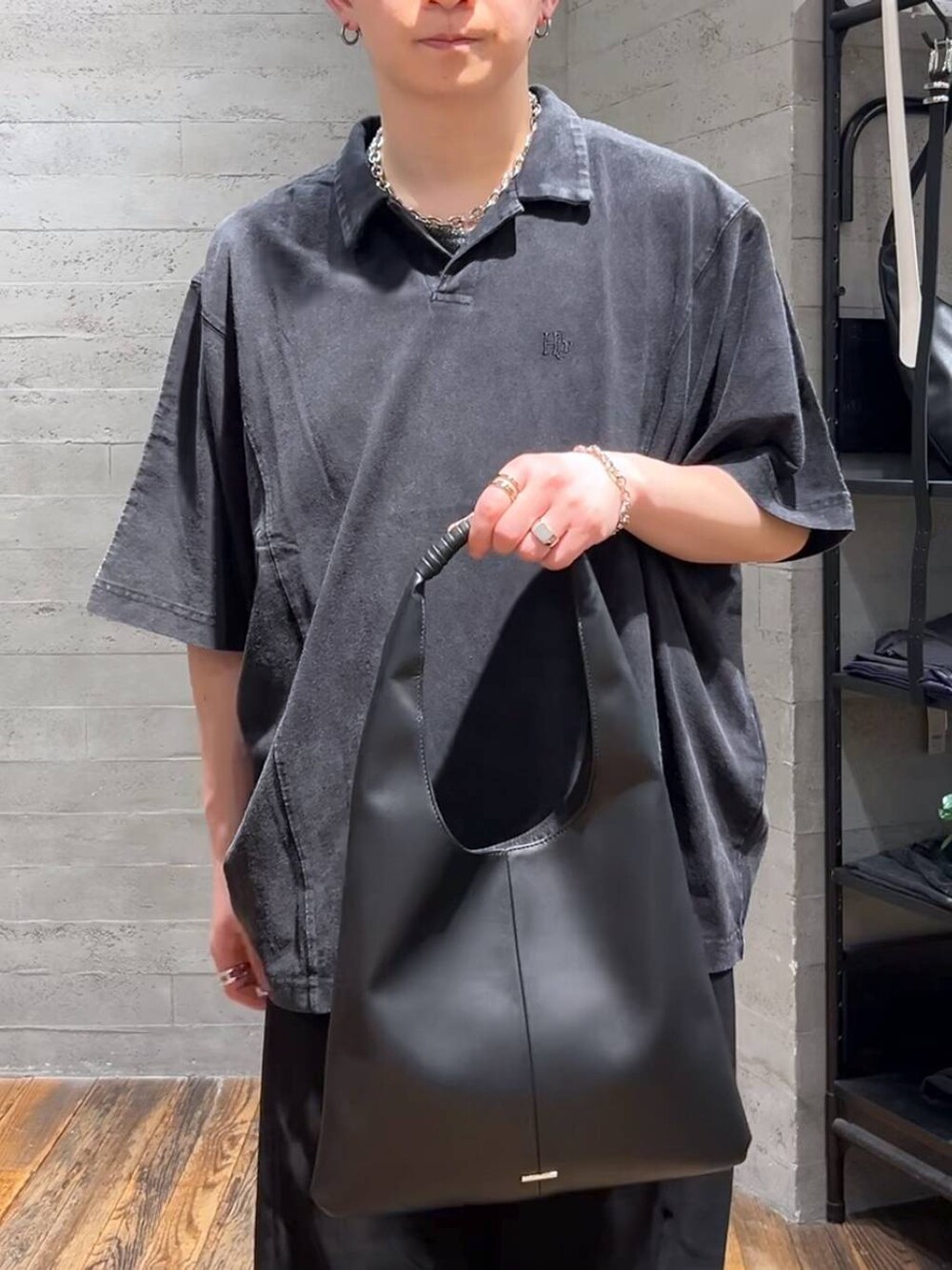 ブラック系のトートバッグ、ブラック系のサンダル、ブラック系のTシャツ/カットソーを着用したメンズの春コーディネートの5枚目の写真