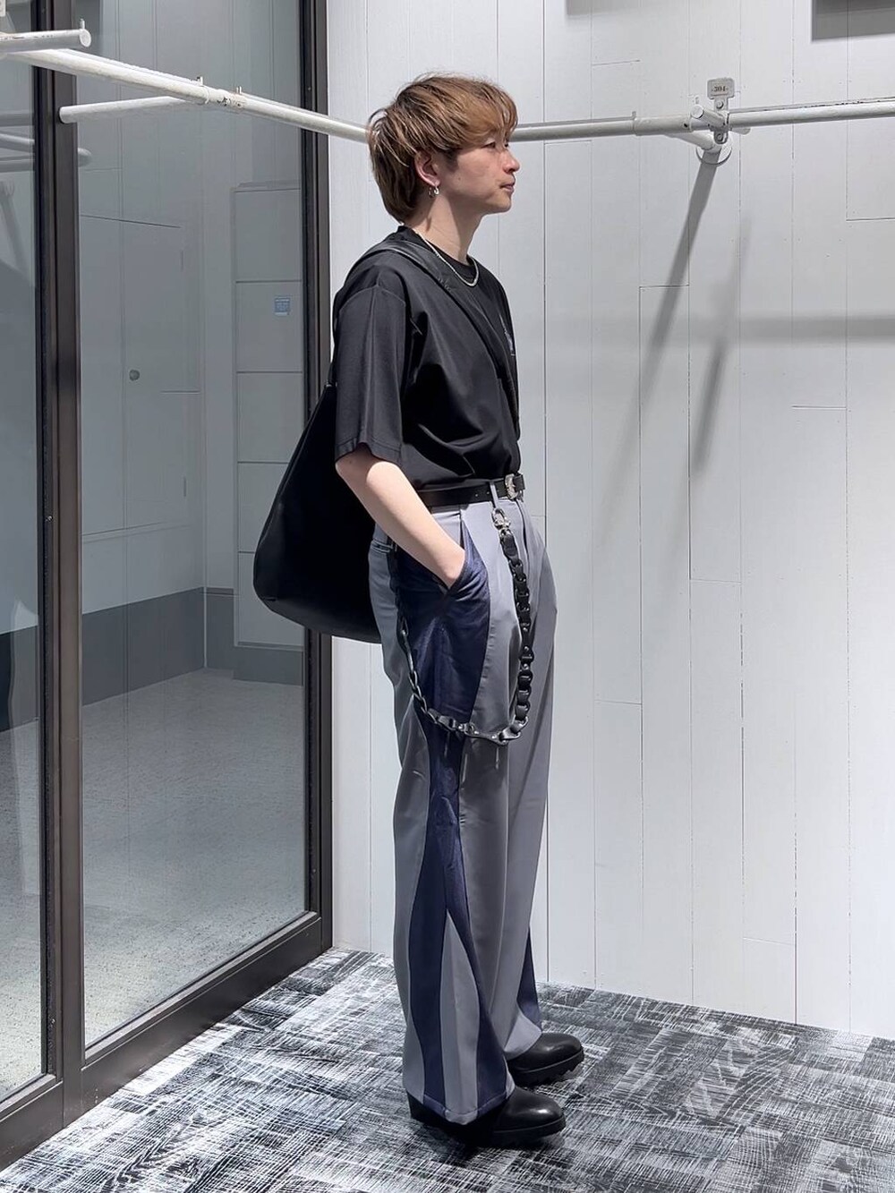 ブラック系のドレスシューズ、ブラック系のTシャツ/カットソー、ブラック系のショルダーバッグを着用したメンズの春コーディネートの3枚目の写真