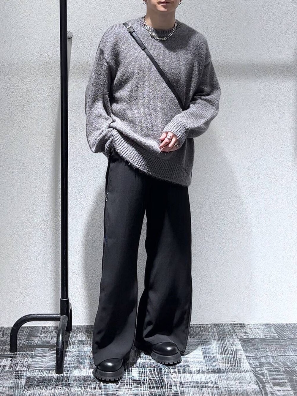 ブラック系のショルダーバッグ、ブラック系のブーツ、ブルー系のスラックスを着用したメンズの秋コーディネートの2枚目の写真