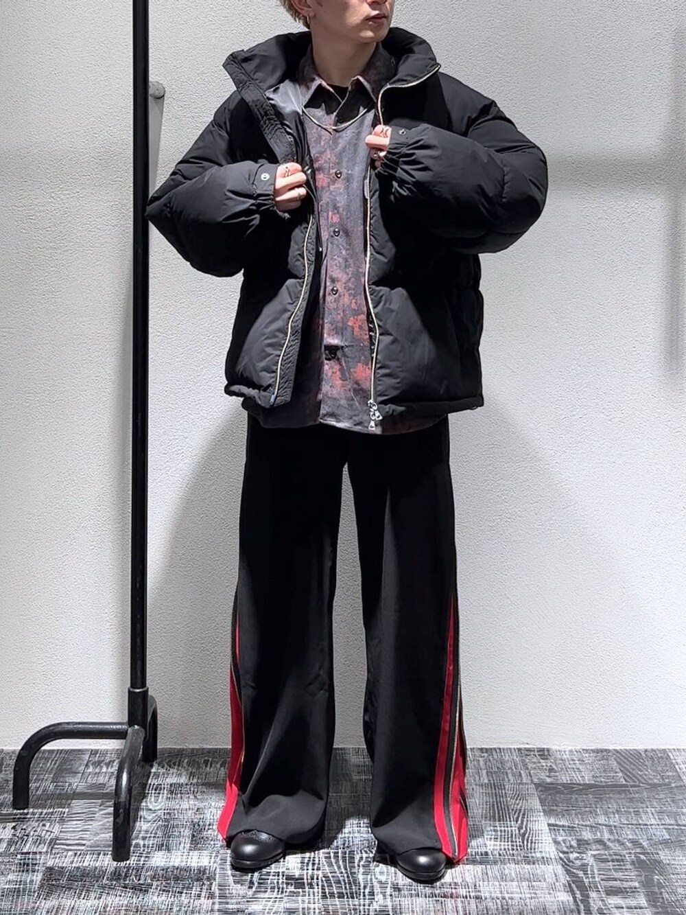 ブラック系のダウンジャケット/コート、レッド系のスラックス、ブラック系のドレスシューズを着用したメンズの秋コーディネートの2枚目の写真