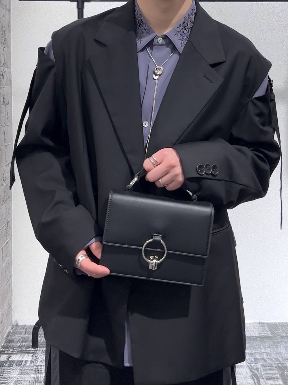 パープル系のシャツ/ブラウス、ブラック系のテーラードジャケット、ブラック系のショルダーバッグを着用したメンズの冬コーディネートの5枚目の写真