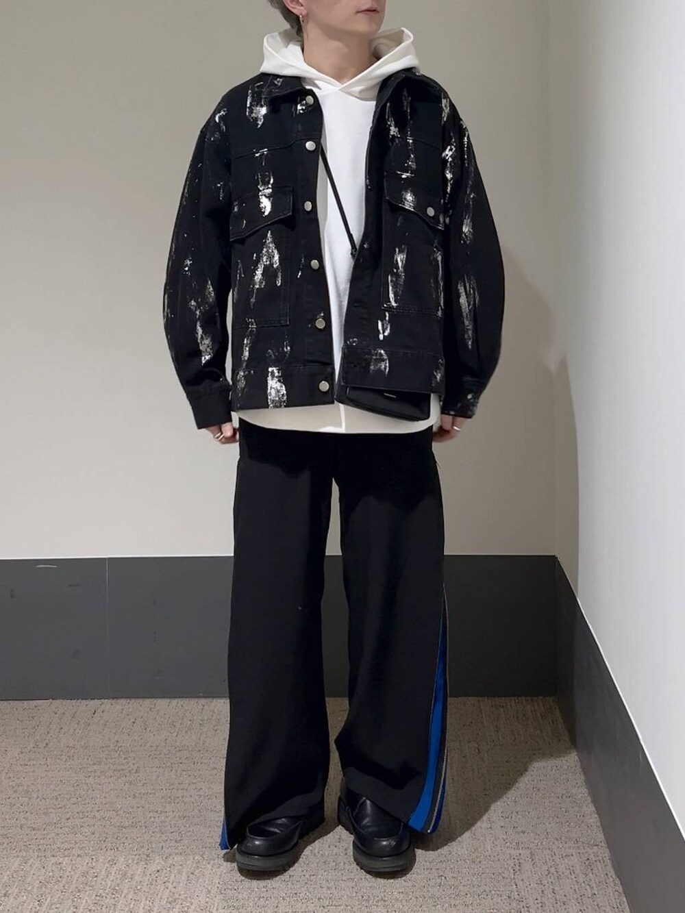 ブラック系のショルダーバッグ、ブラック系のドレスシューズ、ブルー系のスラックスを着用したメンズの冬コーディネートの2枚目の写真