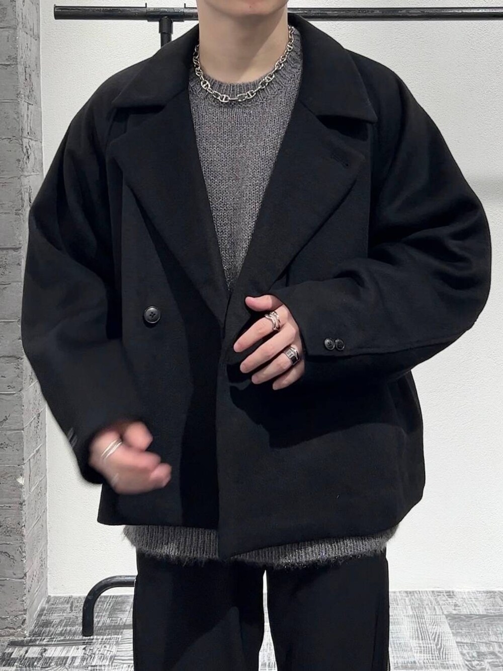 ブラック系のブルゾン、ブラック系のブーツ、ブルー系のスラックスを着用したメンズの秋コーディネートの5枚目の写真