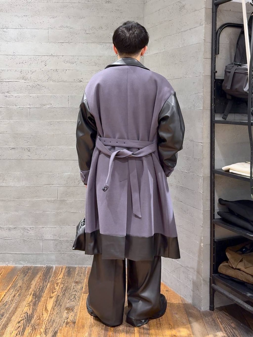 パープル系のトレンチコート、グレー系のニット/セーター、ブラック系のスラックスを着用したメンズの秋コーディネートの3枚目の写真