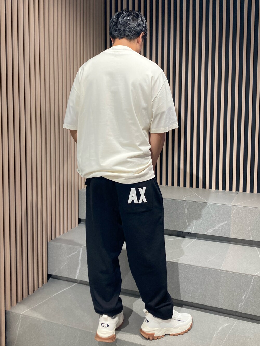 ブラック系のTシャツ/カットソー、ブラック系のスウェットパンツ、ブラック系のボディバッグ/ウエストポーチを着用したメンズの夏コーディネートの2枚目の写真