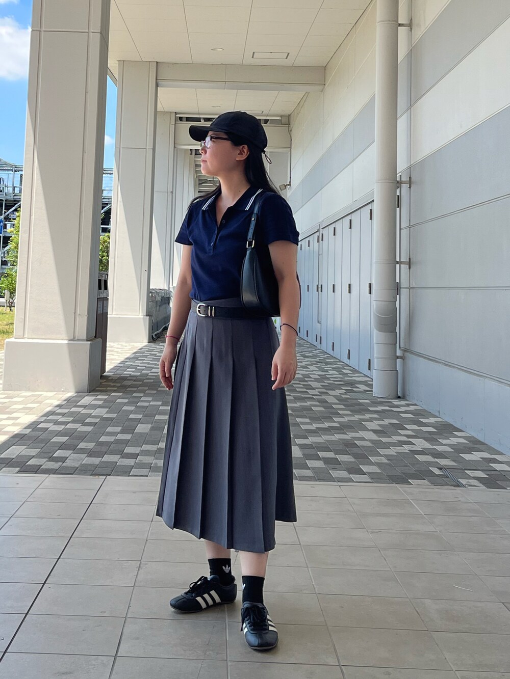 ブラック系のスニーカー、その他のポロシャツ、グレー系のスカートを着用したレディースの夏コーディネートの3枚目の写真