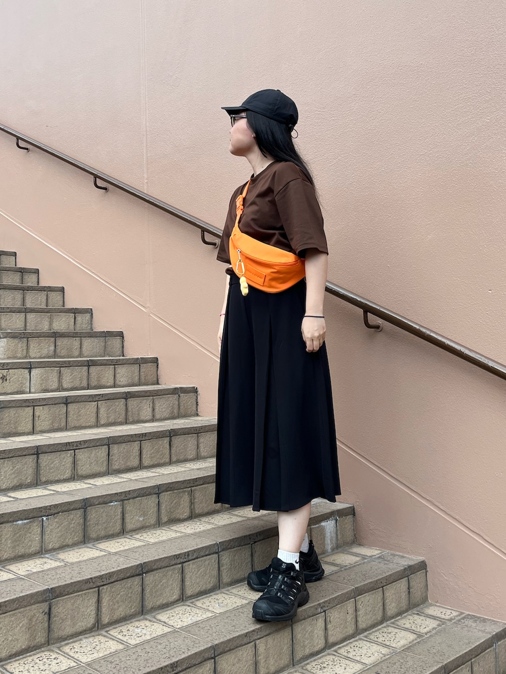 ブラウン系のTシャツ/カットソー、オレンジ系のショルダーバッグ、ブラック系のその他パンツを着用したレディースの夏コーディネートの2枚目の写真