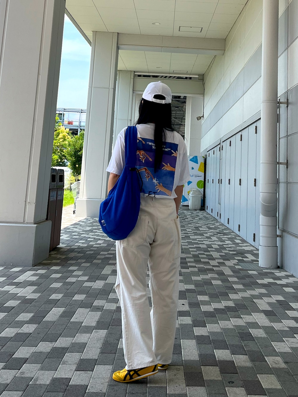 ブルー系のショルダーバッグ、ホワイト系のTシャツ/カットソー、イエロー系のスニーカーを着用したレディースの夏コーディネートの3枚目の写真