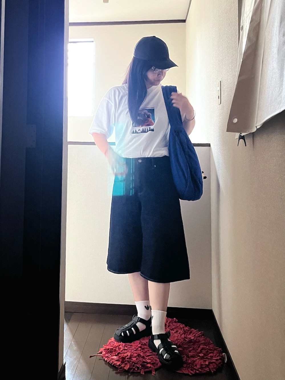 ブラック系のサンダル、ブルー系のその他パンツ、ホワイト系のTシャツ/カットソーを着用したレディースの夏コーディネートの2枚目の写真