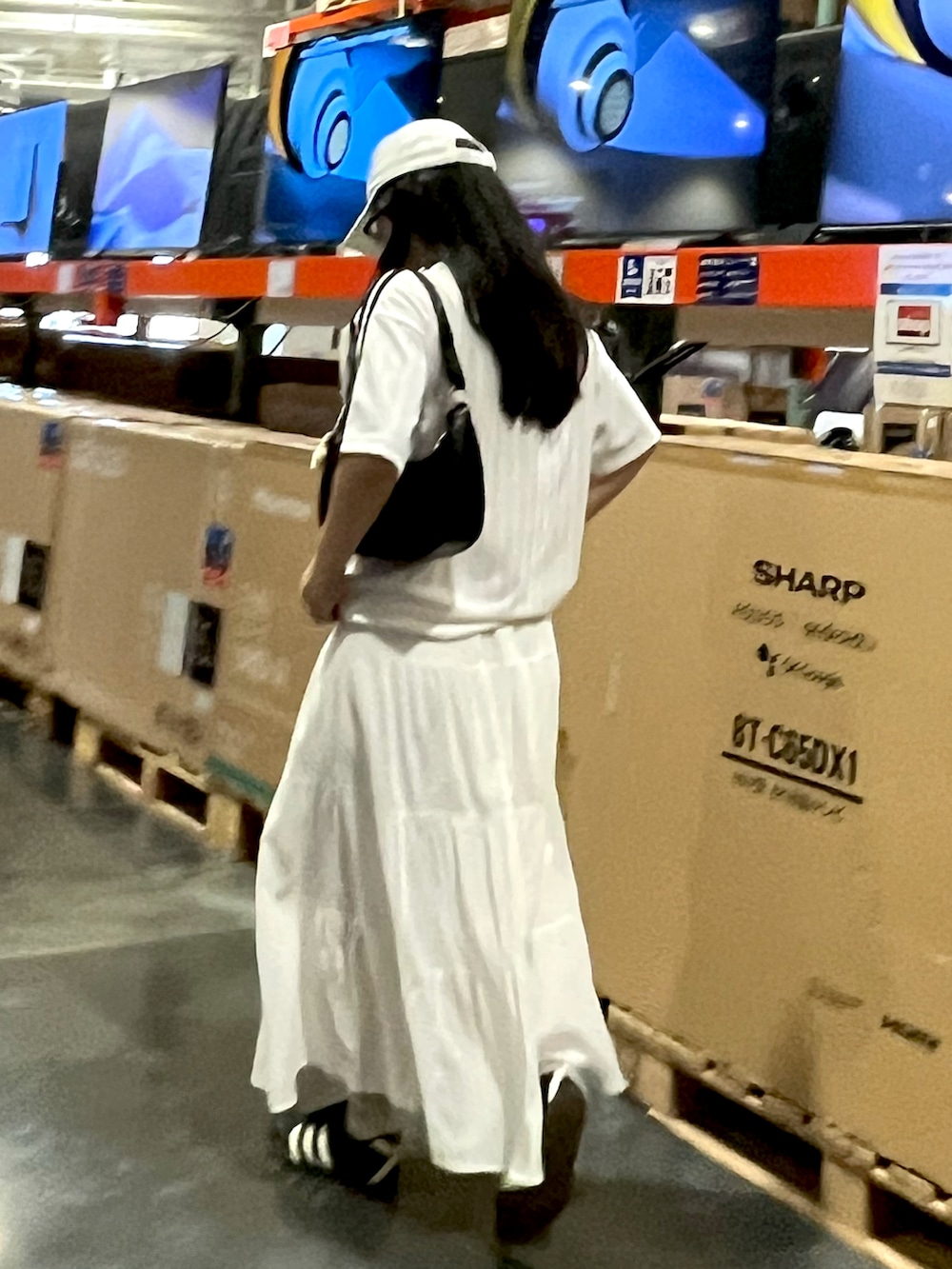 ブラック系のスニーカー、ホワイト系のスカート、ホワイト系のTシャツ/カットソーを着用したレディースの夏コーディネートの4枚目の写真