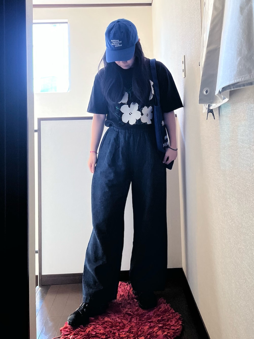 ブラック系のスニーカー、ブルー系のその他パンツ、ブラック系のTシャツ/カットソーを着用したレディースの夏コーディネートの2枚目の写真