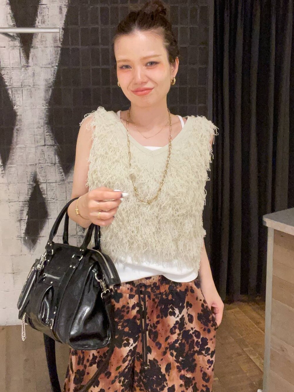 ブラック系のボストンバッグ、ホワイト系のタンクトップ、ブラック系のサンダルを着用したレディースの夏コーディネートの7枚目の写真