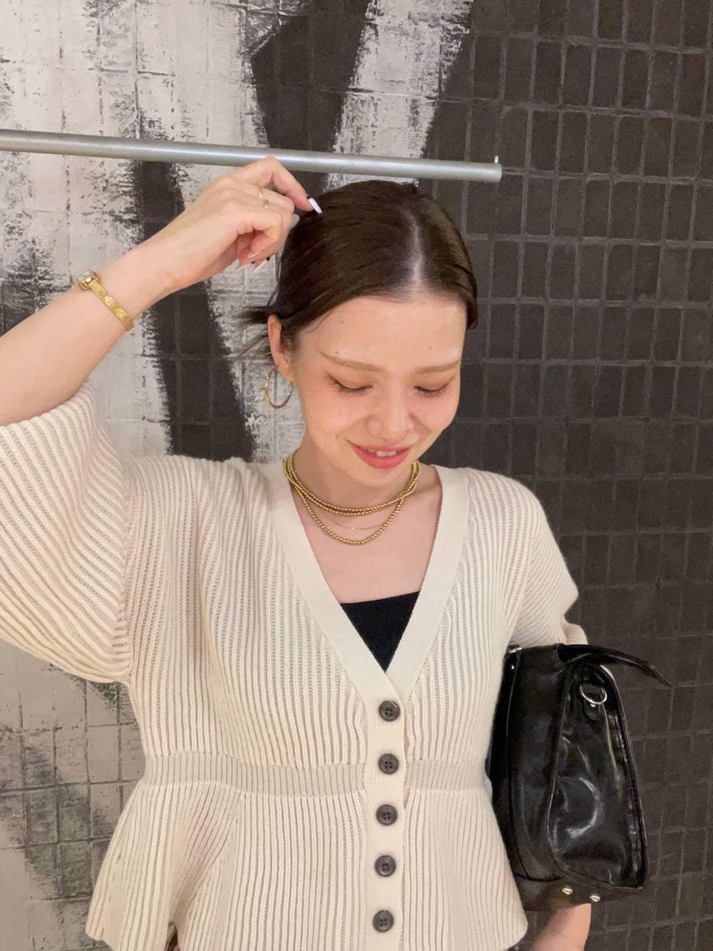 ブラック系のボストンバッグ、ブラウン系のその他シューズ、ホワイト系のカーディガン/ボレロを着用したレディースの冬コーディネートの2枚目の写真