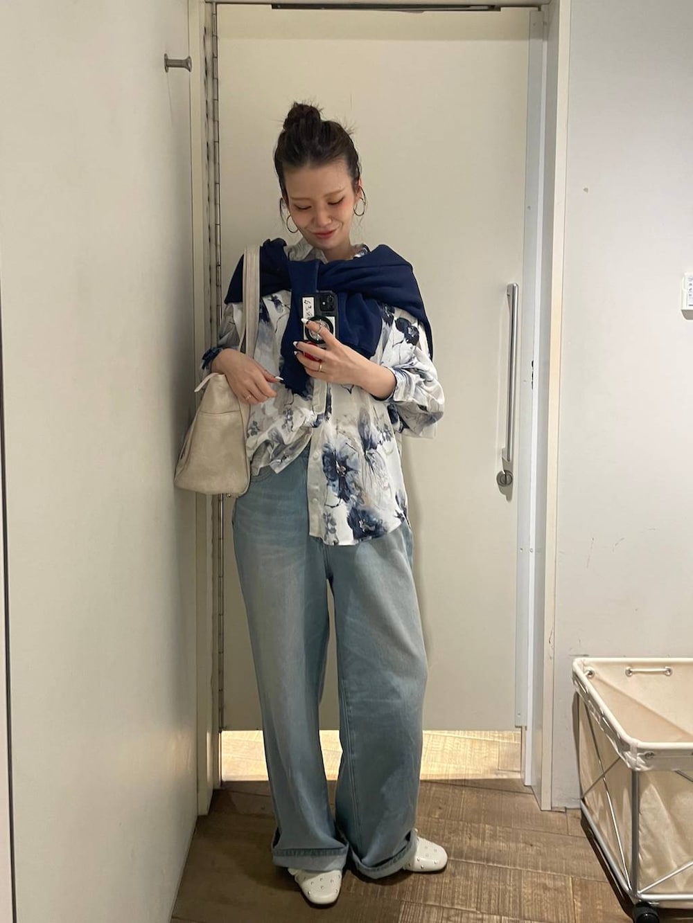 ホワイト系のトートバッグ、ホワイト系のドレスシューズ、ブルー系のスウェットを着用したレディースの春コーディネートの2枚目の写真