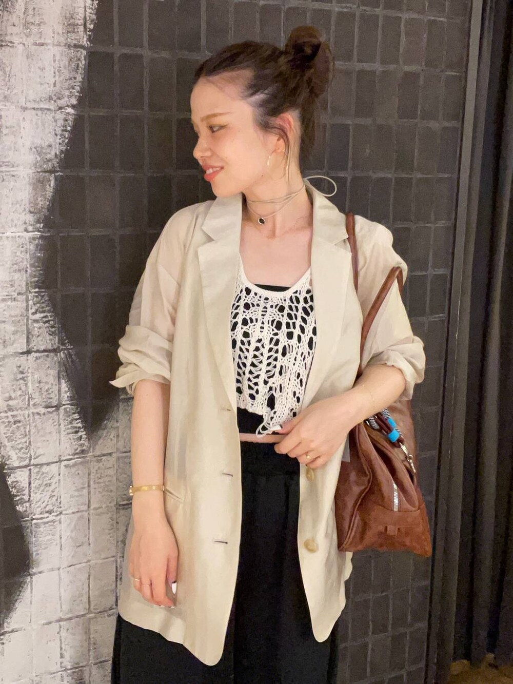 ホワイト系のベスト、ブラック系のサンダル、ブラウン系のボストンバッグを着用したレディースの夏コーディネートの7枚目の写真